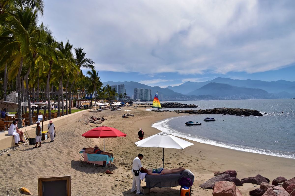 Playa tranquila de bahía en Puerto Vallarta con aguas azules calmadas y palmeras