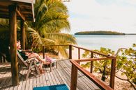 A serene tropical deck overlooking a scenic beach, perfect for relaxation and vacation vibes.
