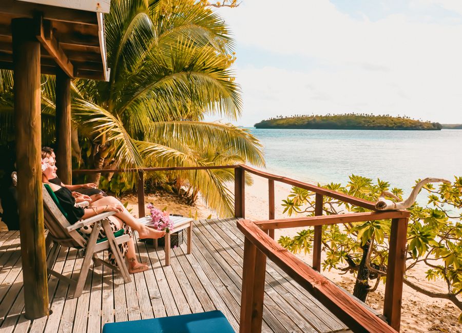 A serene tropical deck overlooking a scenic beach, perfect for relaxation and vacation vibes.