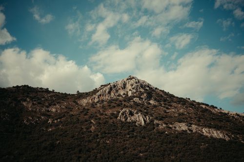Free A stunning rocky mountain under a partially cloudy sky, offering a serene natural view. Stock Photo