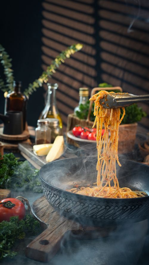 Free Delicious steaming pasta served in rustic kitchen with fresh ingredients. Stock Photo