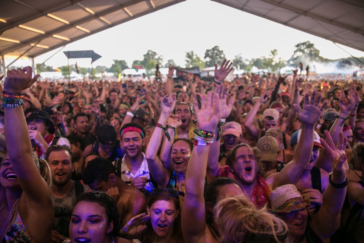 excited crowd enjoying a vibrant music festival under a tent during th