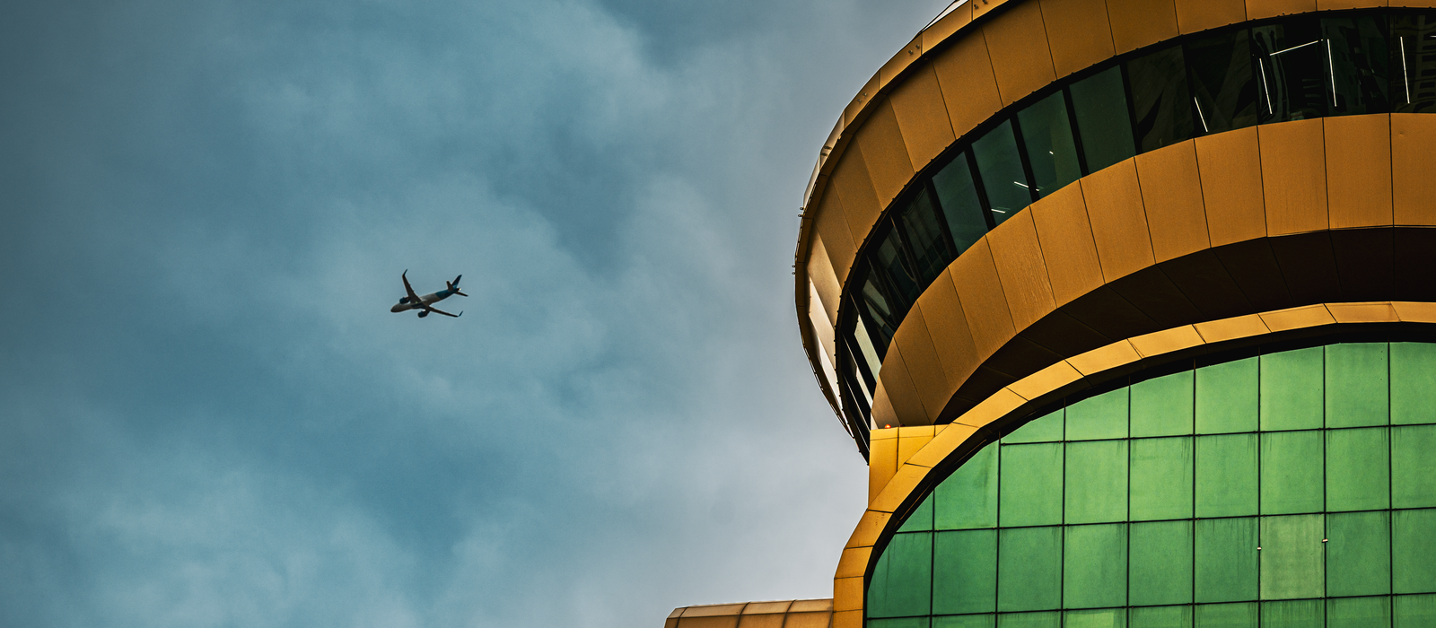 A captivating view of modern architecture in Kuwait City with an airplane in the sky. — flights from Luxor to Kuwait City