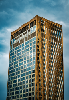 Striking view of a contemporary skyscraper in Kuwait City under a moody sky.