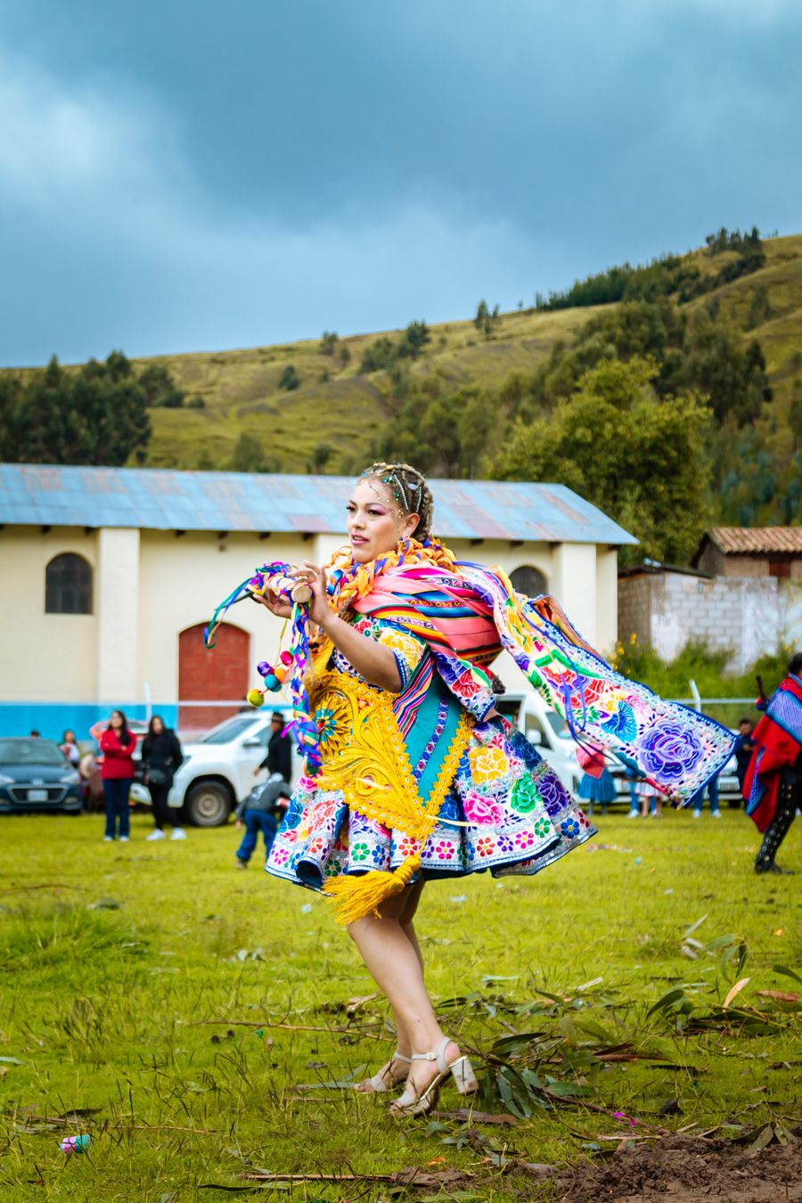 A dancer in traditional dress in an open field — Enrique Yllpa on Pexels