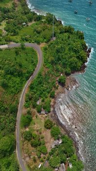 Aerial shot of a winding road along the lush green coastline of West Java, Indonesia. - Fotografer Sidoarjo