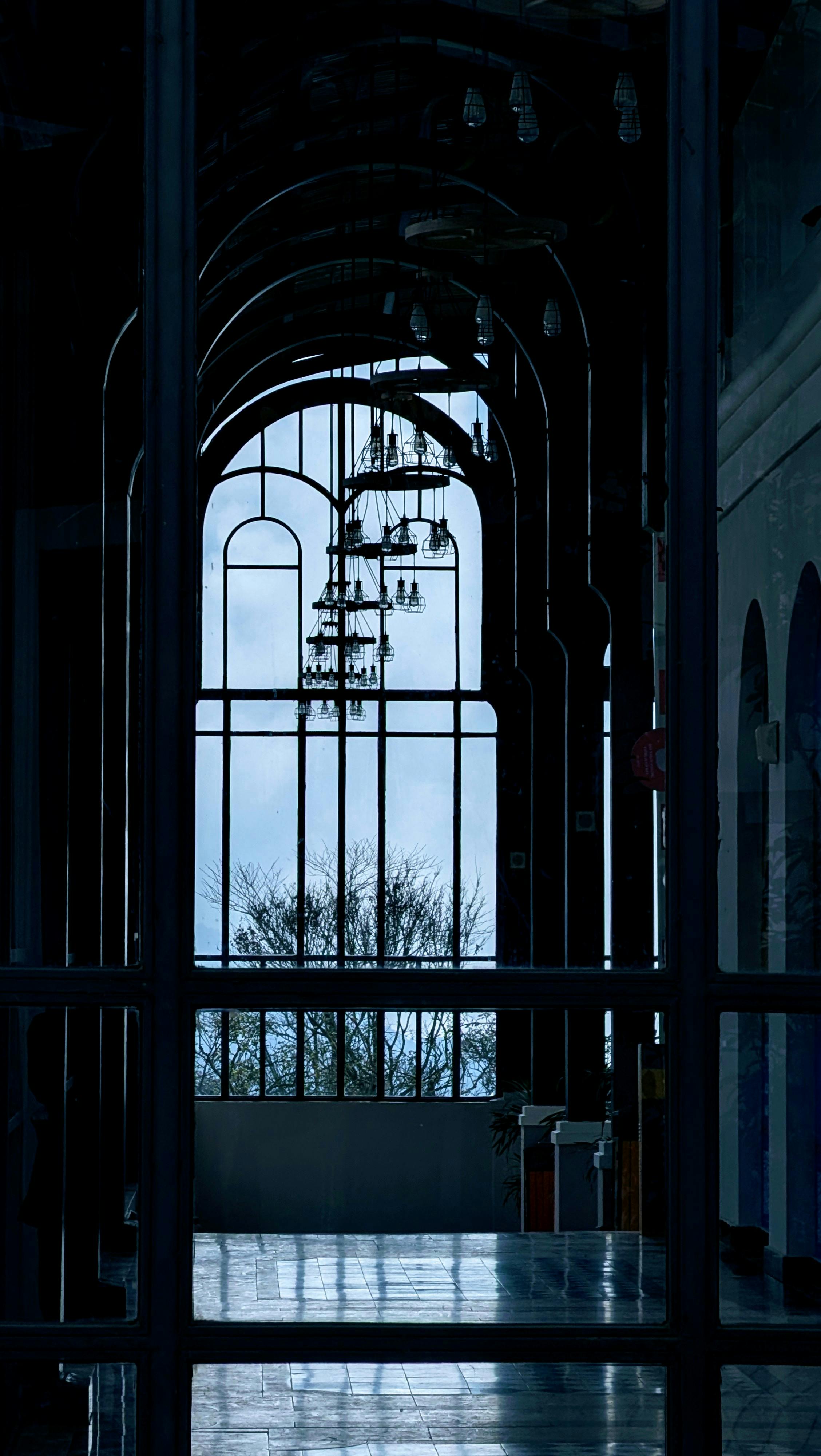 бесплатная В городе Лаокай, Вьетнам, замысловатый арочный коридор с люстрами и окнами, создающими атмосферную обстановку. Стоковое фото