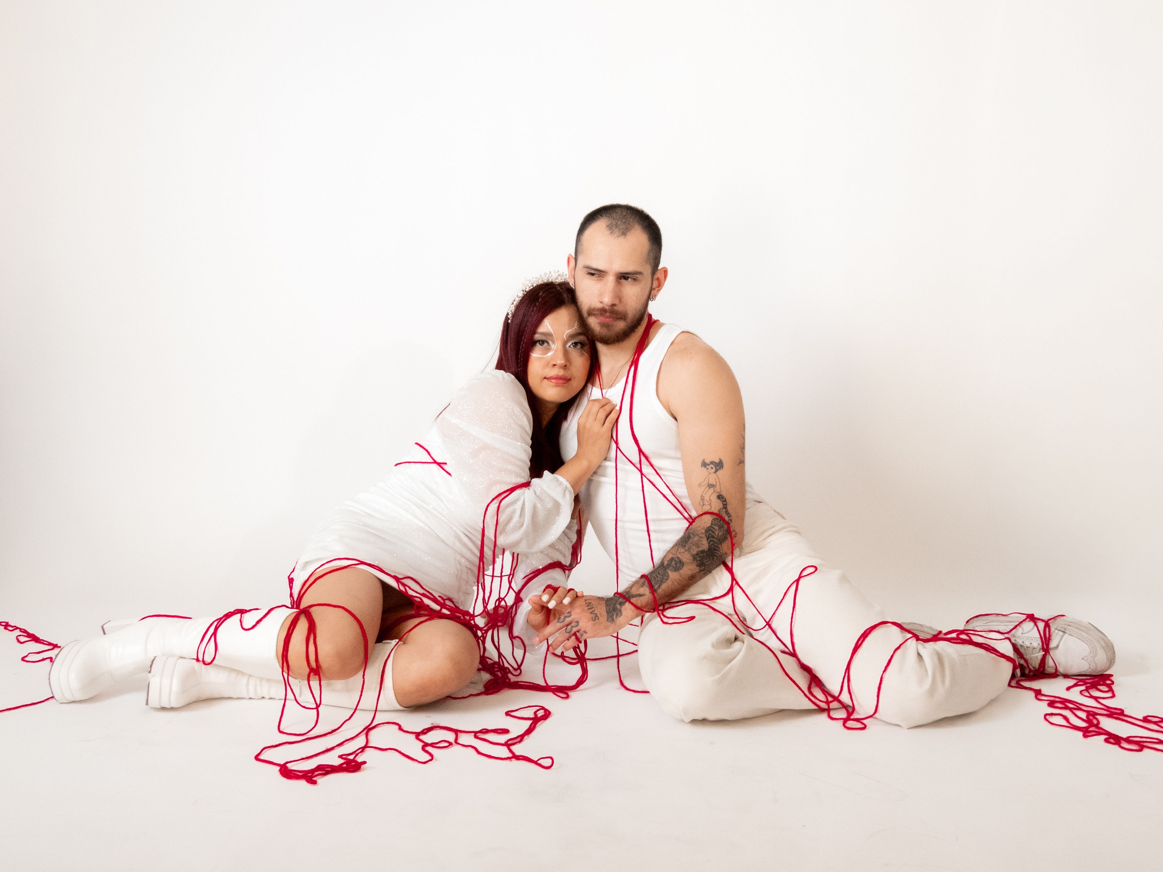Romantic Couple Wrapped in Red Thread in Studio · Free Stock Photo