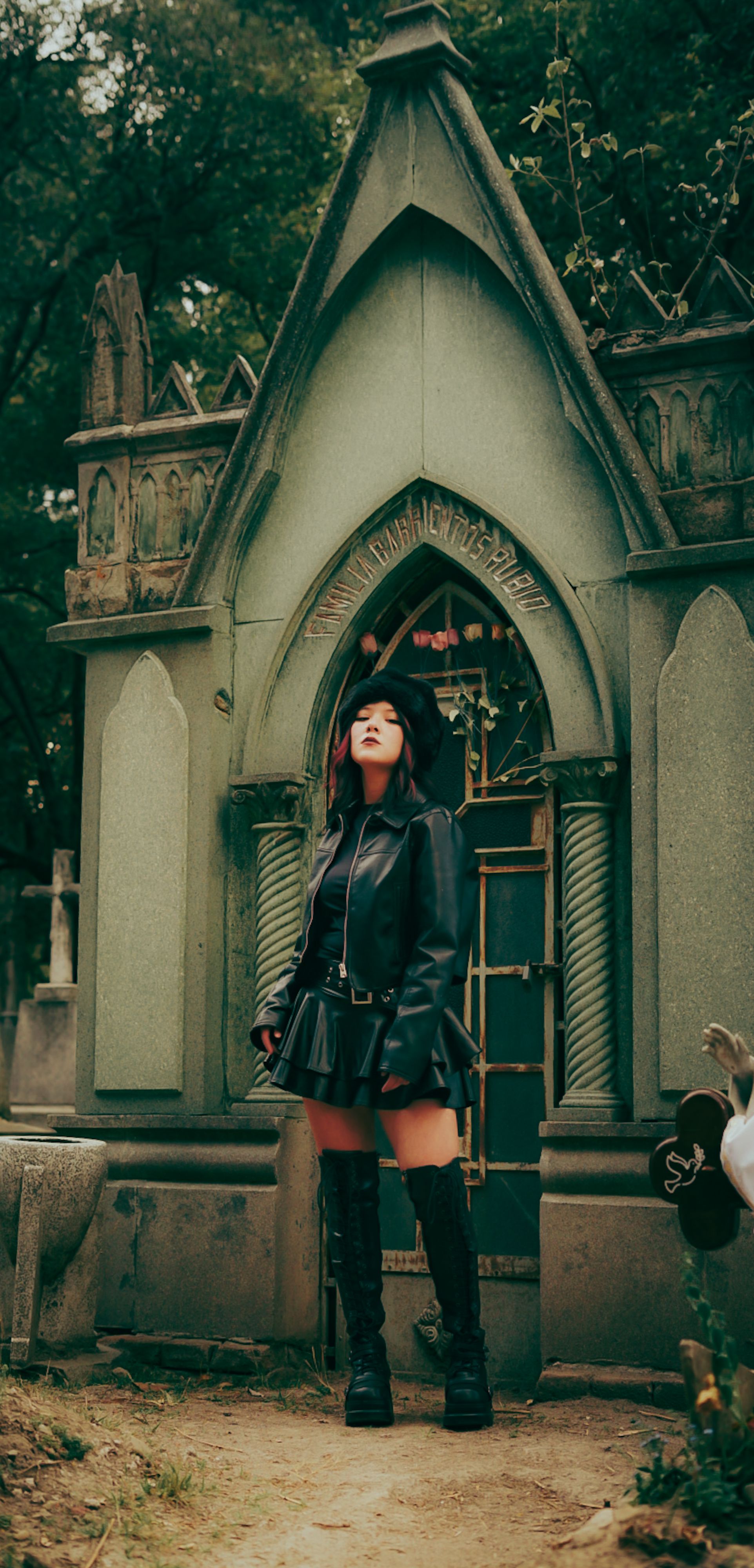 gothic woman in cemetery by mausoleum