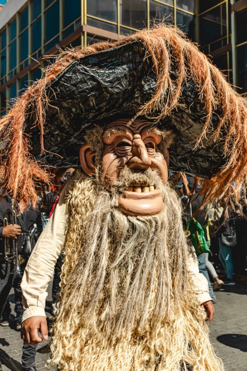 Free Colorful participant in Mexican street parade, Pachuca, featuring an elaborate costume with a large mask and hat. Stock Photo