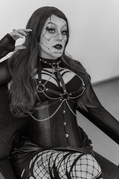 Striking black and white portrait featuring cyberpunk fashion and artistic makeup, highlighting a black corset and leather attire.