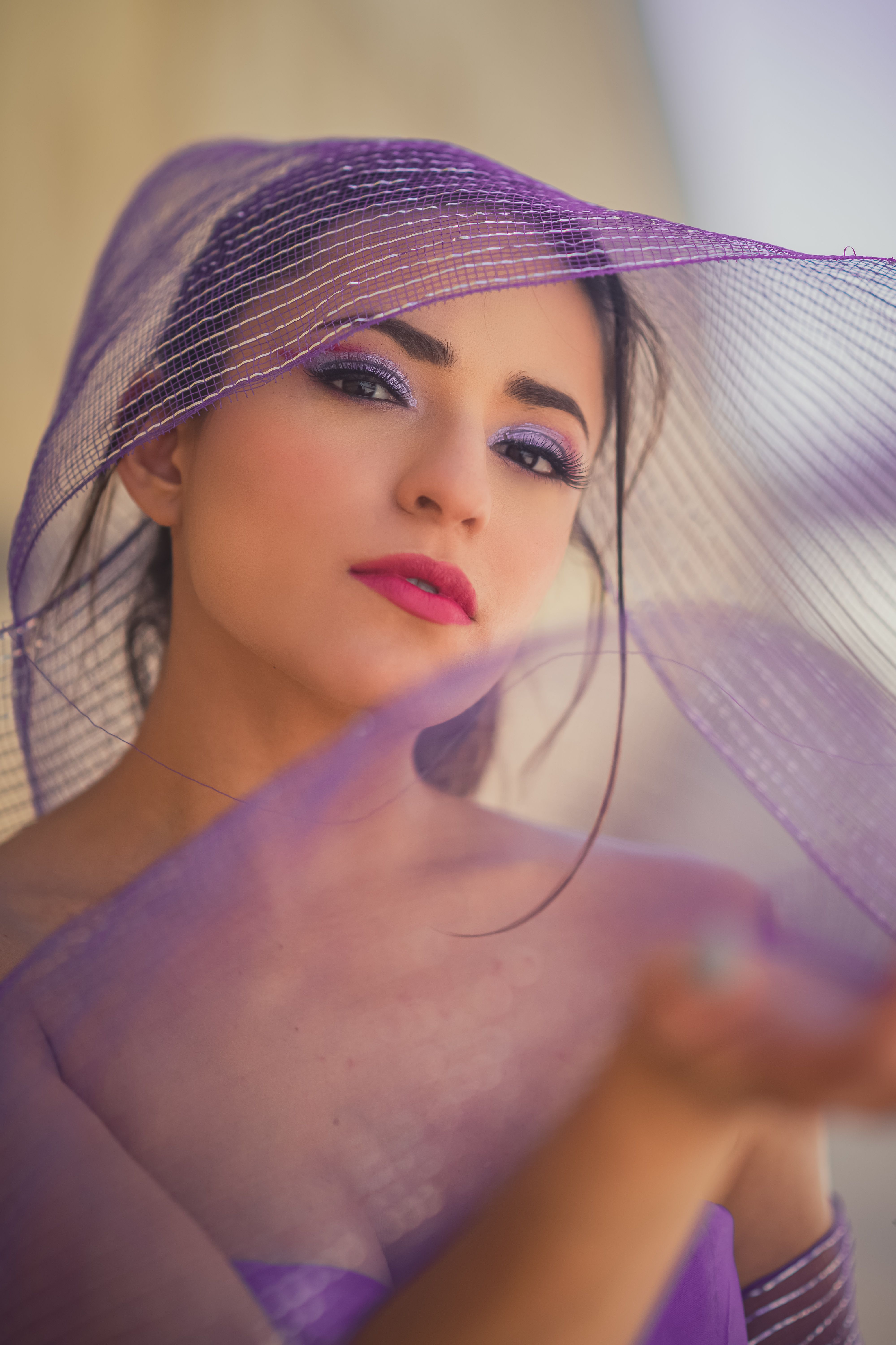 Captivating portrait of a woman in purple veil, exuding elegance with soft lighting and modern style.
