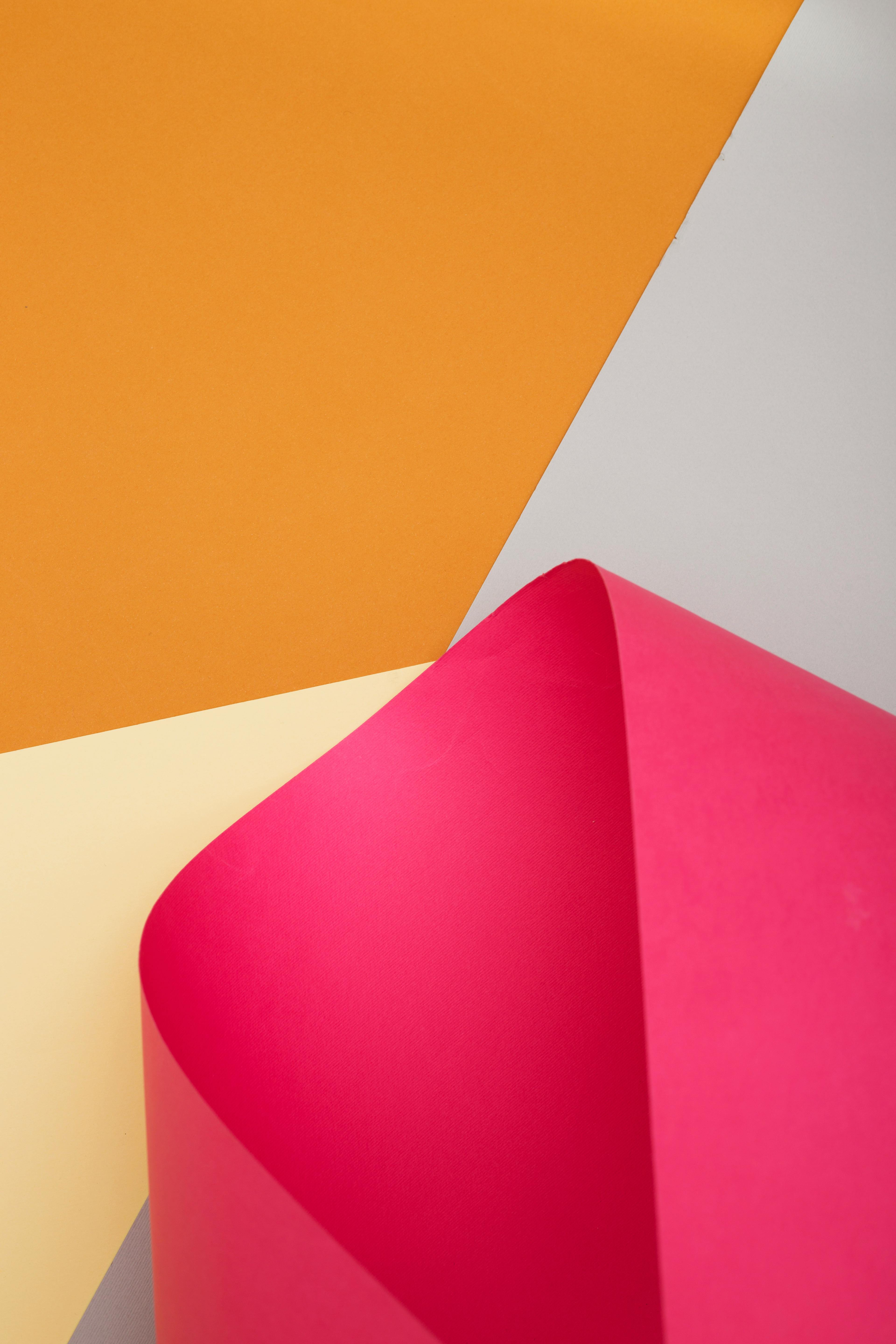 Free Vibrant abstract photo with layered colorful paper in pink, orange, and yellow hues. Stock Photo