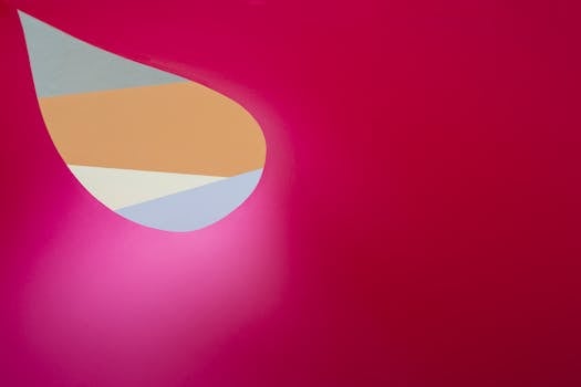 A colorful abstract design with geometric shapes on a bright pink background, creating a playful and modern visual.