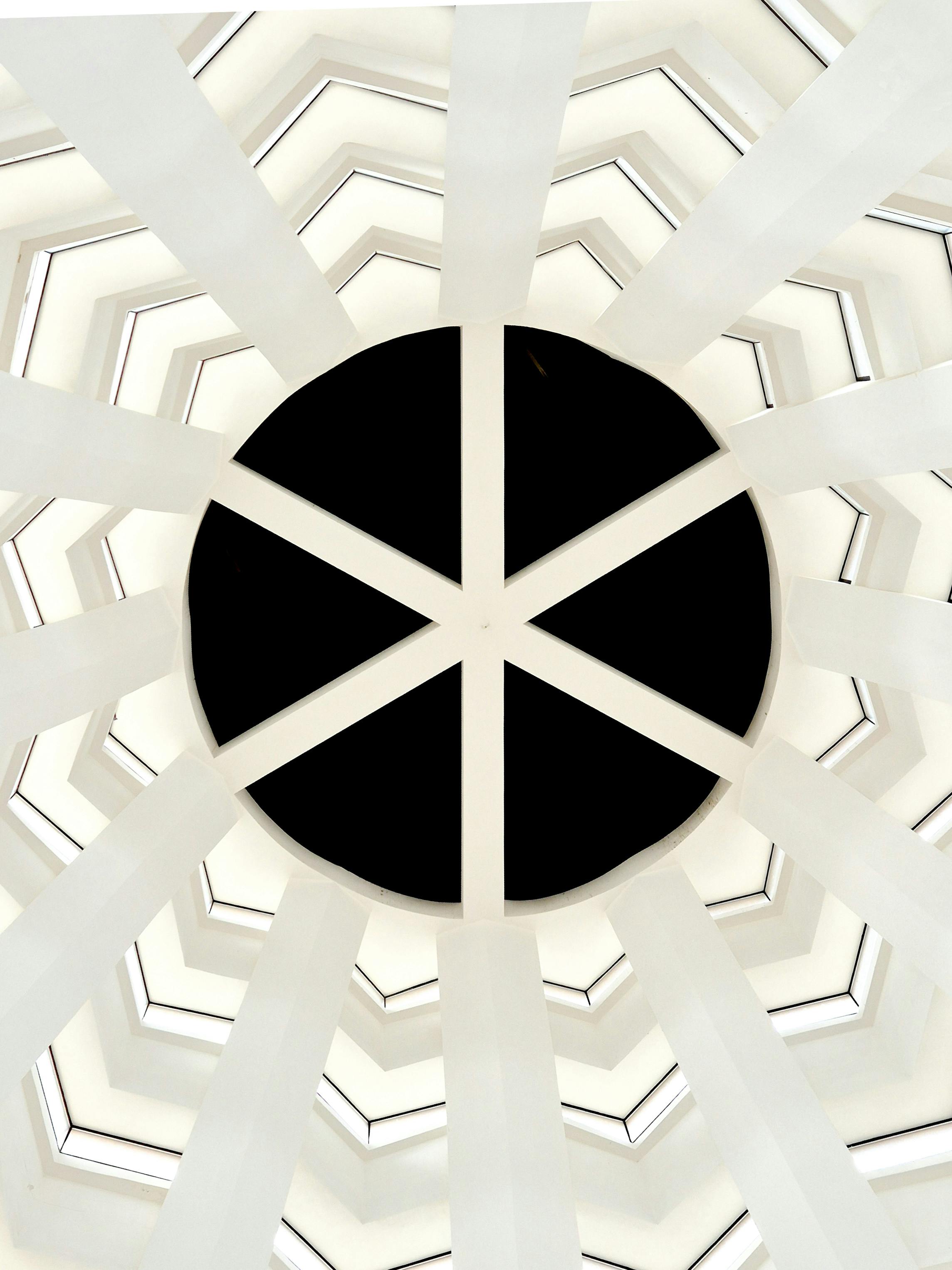 gratis Abstracte weergave van een cirkelvormig geometrisch dakraam met radiale symmetrie, wat een modern en artistiek effect creëert. Stockfoto