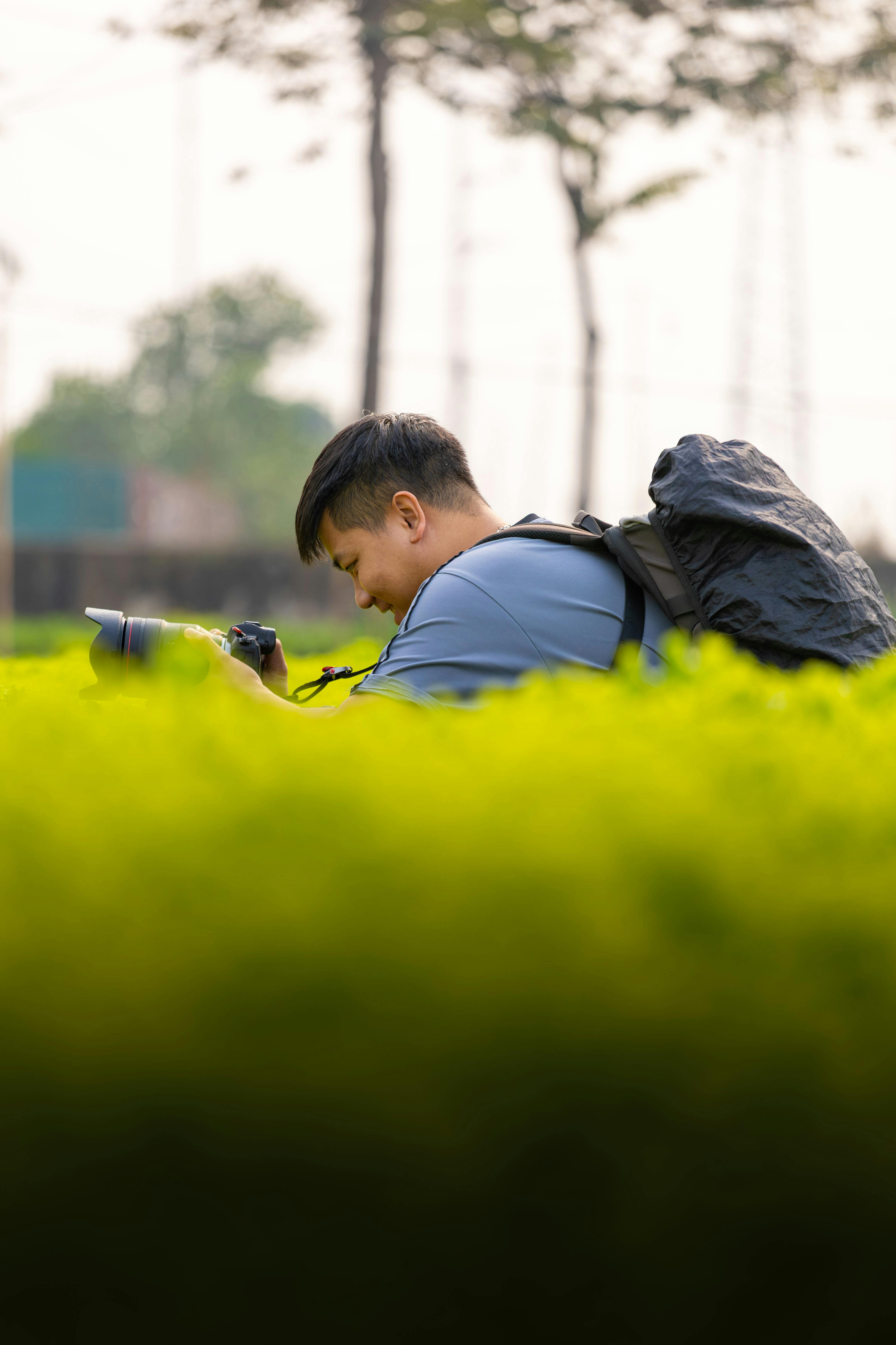 A dedicated photographer amidst greenery in Hanoi, Vietnam, capturing the beauty of nature.