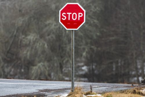Free A red stop sign stands on a foggy road in winter in Jönköping, Sweden. Stock Photo