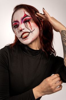 Vibrant clown makeup on Latina woman in black blouse, showcasing artistic expression.