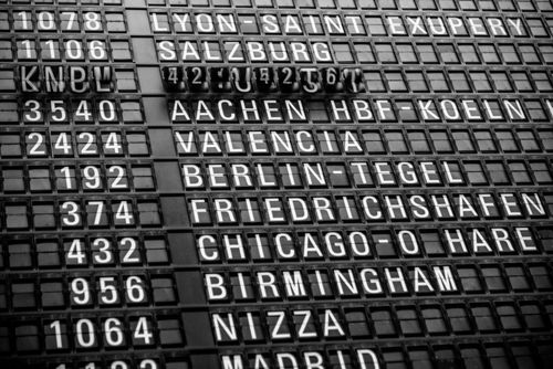 Free Black and white image of a vintage airport departure board displaying various international destinations. Stock Photo