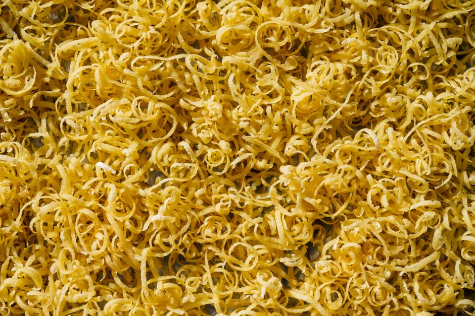 A spiralizer being used to create long zucchini noodles - zucchini pasta Mediterranean style A spiralizer being used to create long zucchini noodles - zucchini pasta Mediterranean style