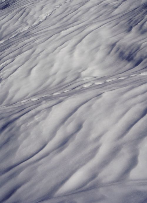 Free Detailed view of snow with unique ripples and patterns creating an abstract and artistic appearance. Stock Photo