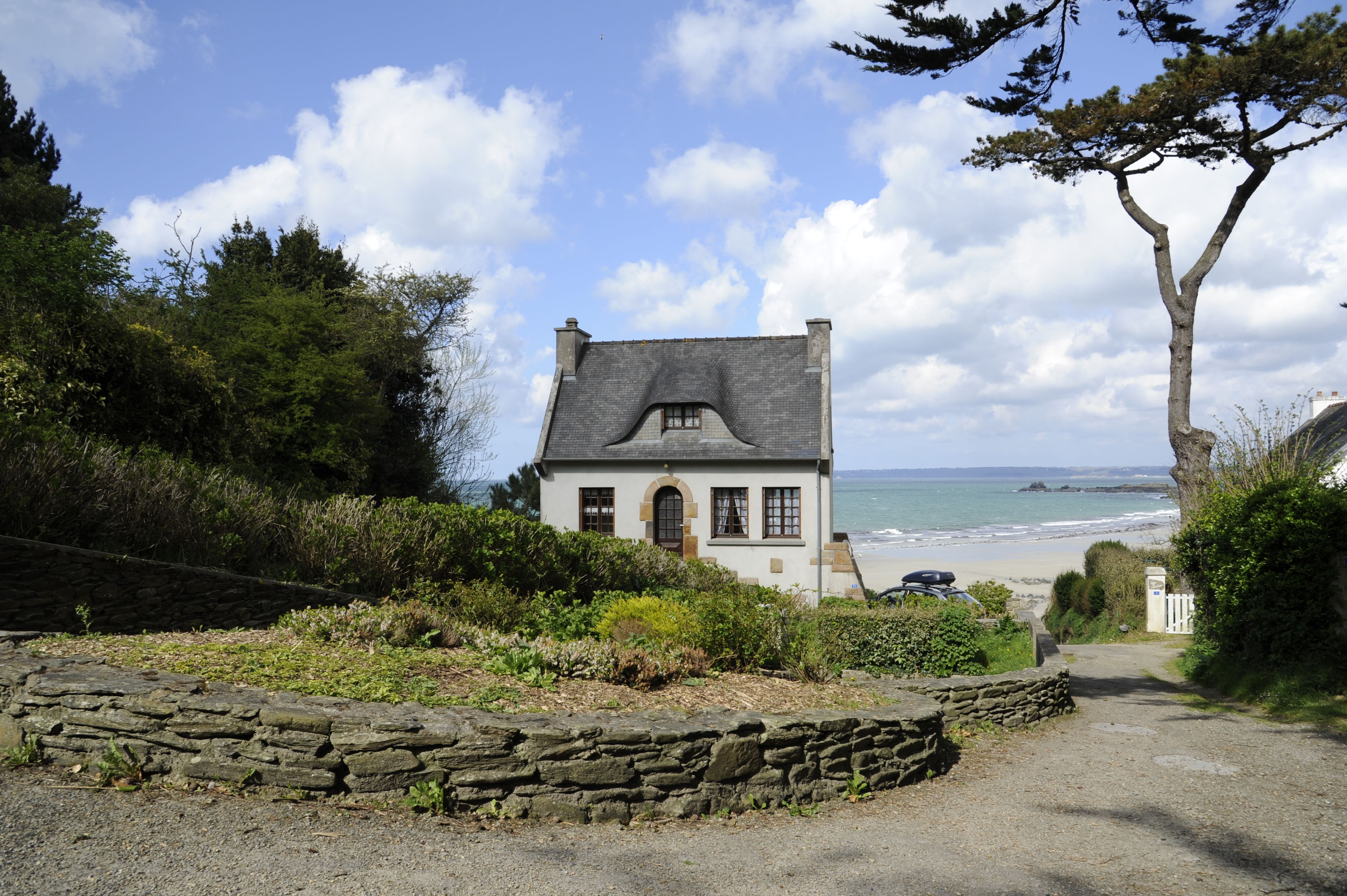 Picturesque cottage near the sea in Bretagne, France, surrounded by lush greenery.