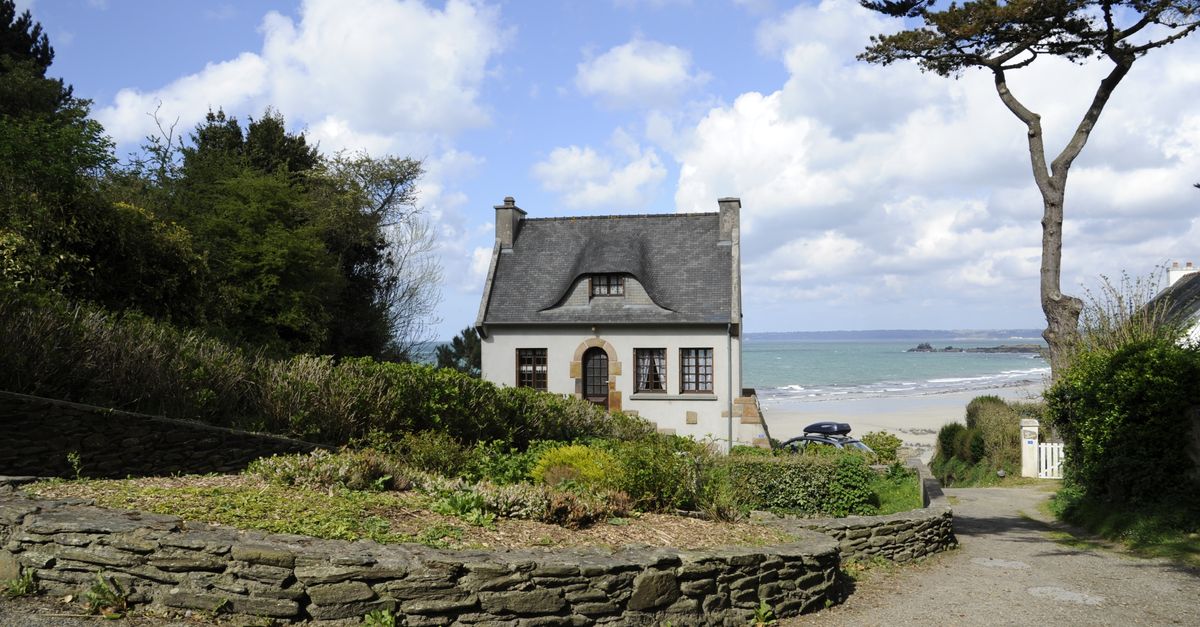 Picturesque cottage near the sea in Bretagne, France, surrounded by lush greenery.
