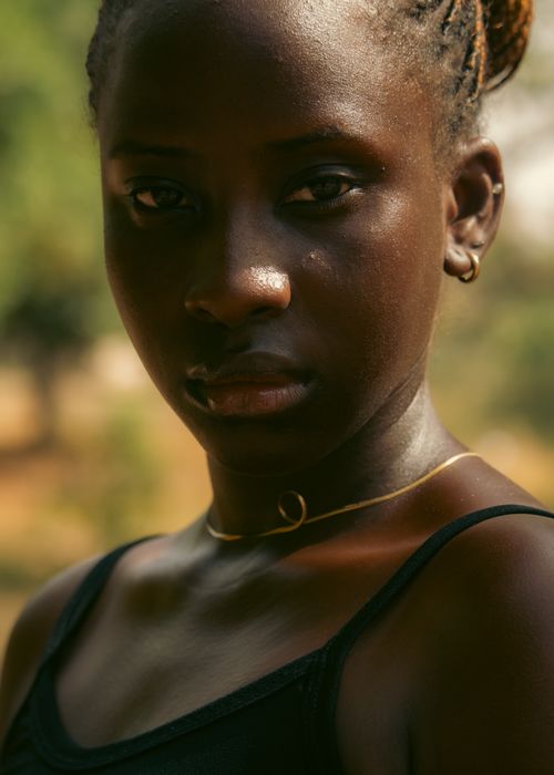 Free Close-up portrait of a young woman enjoying natural light outdoors. Stock Photo
