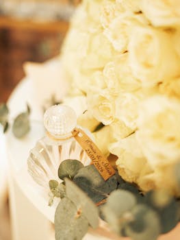 Close-up of wedding decor featuring a perfume bottle with roses, ideal for romantic settings.