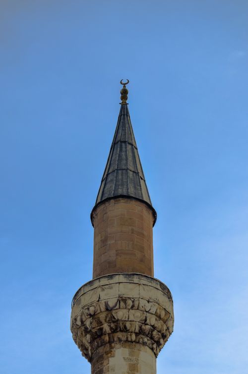 Free A detailed view of an intricately designed mosque minaret under a bright sky. Stock Photo