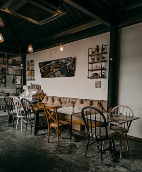 Inviting rustic bistro interior featuring a mix of wooden chairs and tables, exuding warmth and charm.