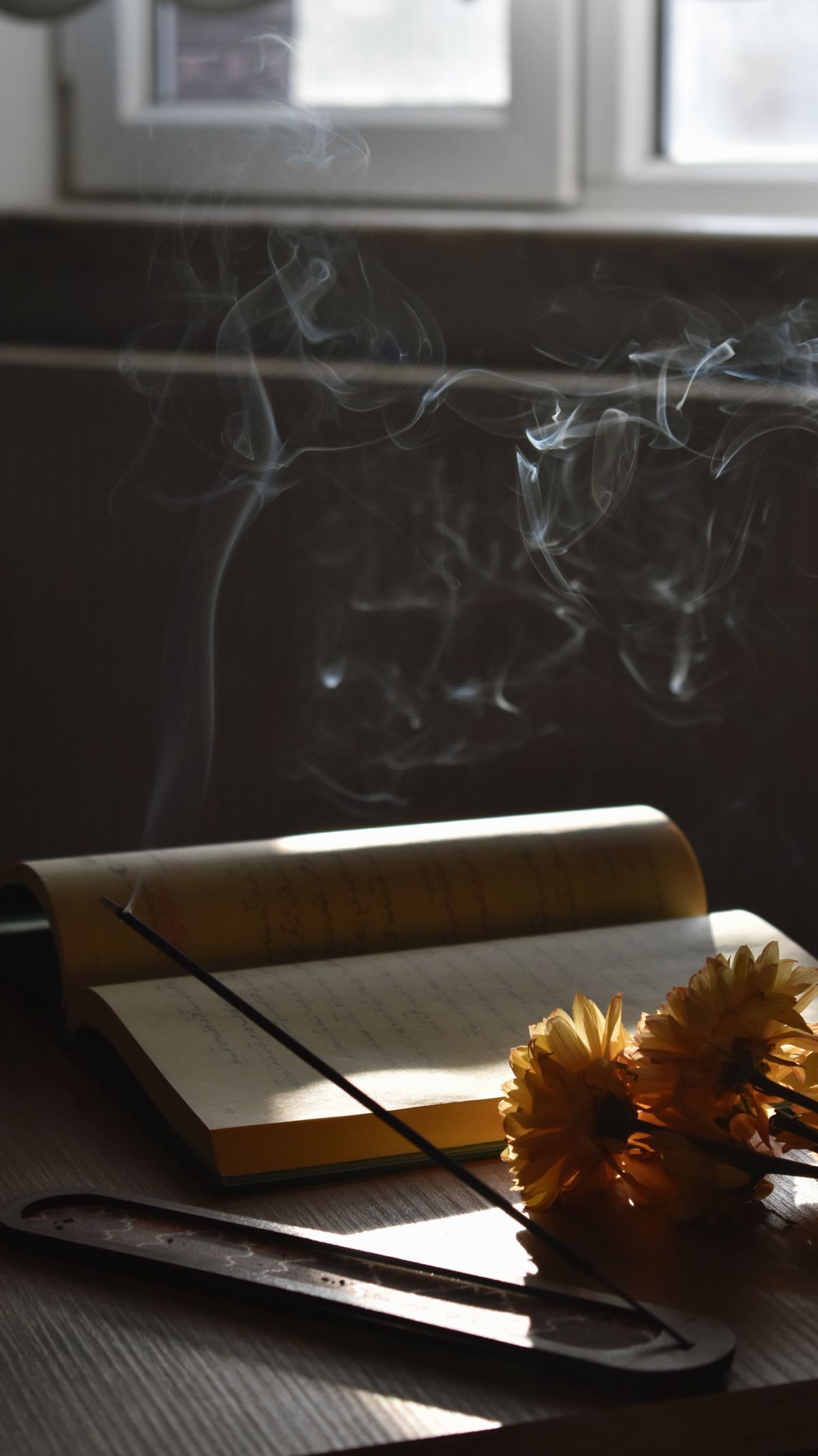 Caderno em ambiente contemplativo com fumaça de incenso e luz natural suave