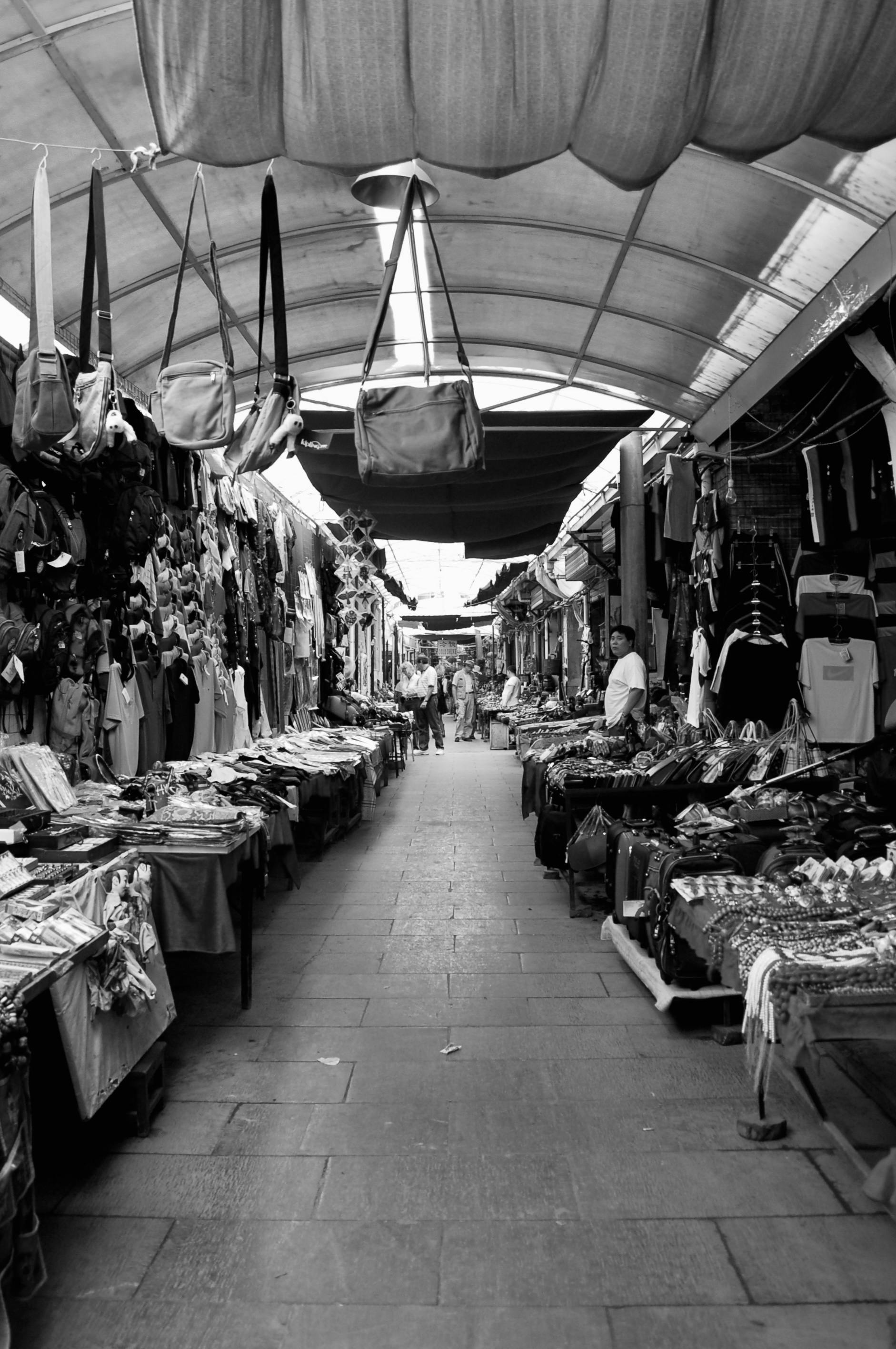 Gratis Foto hitam putih yang hidup dari pasar jalanan dalam ruangan dengan berbagai macam barang dagangan. Foto Stok