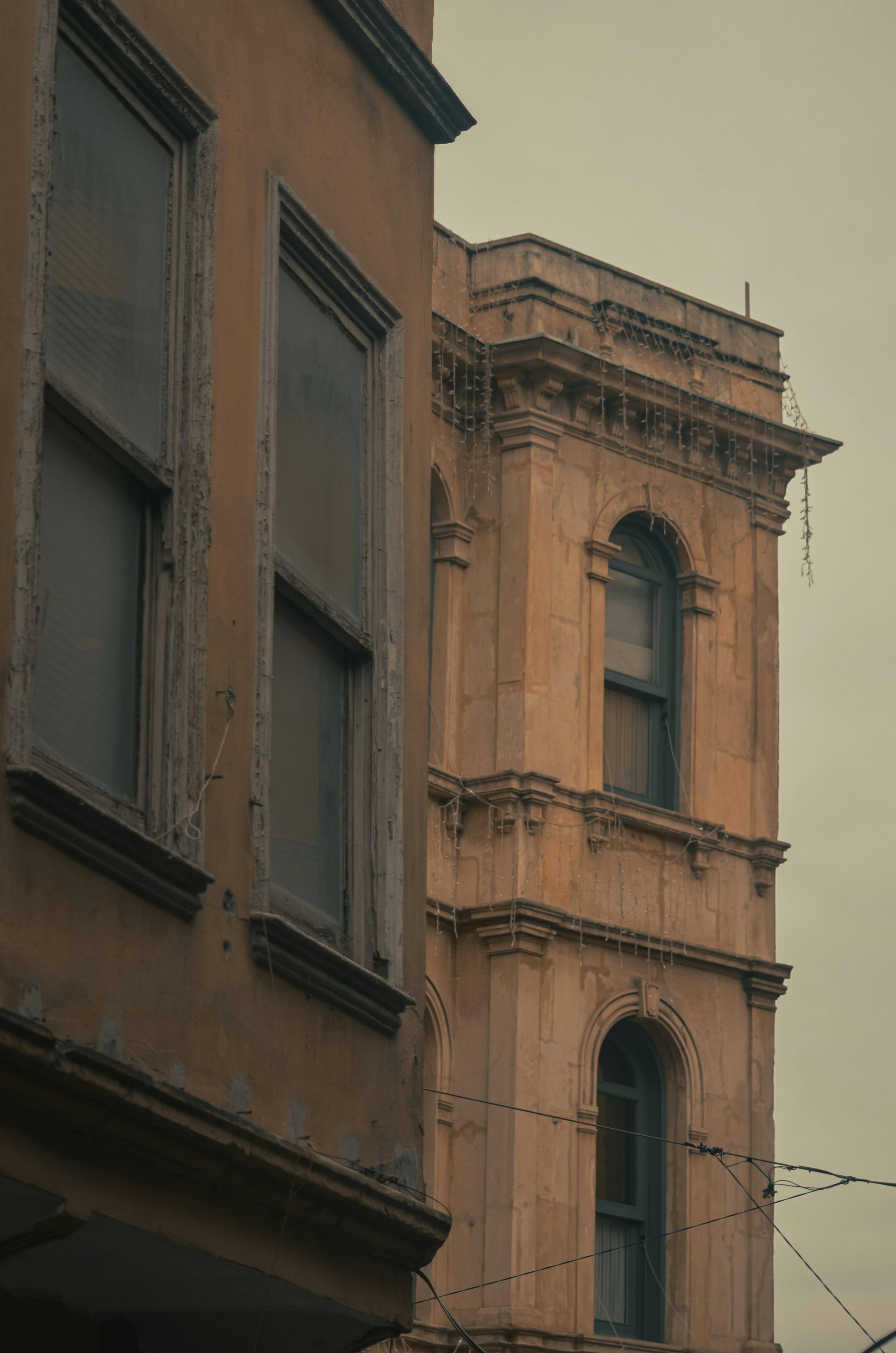 Gratis Ældre arkitektoniske facader med vintage-elementer i blød, dæmpet belysning. Lagerfoto