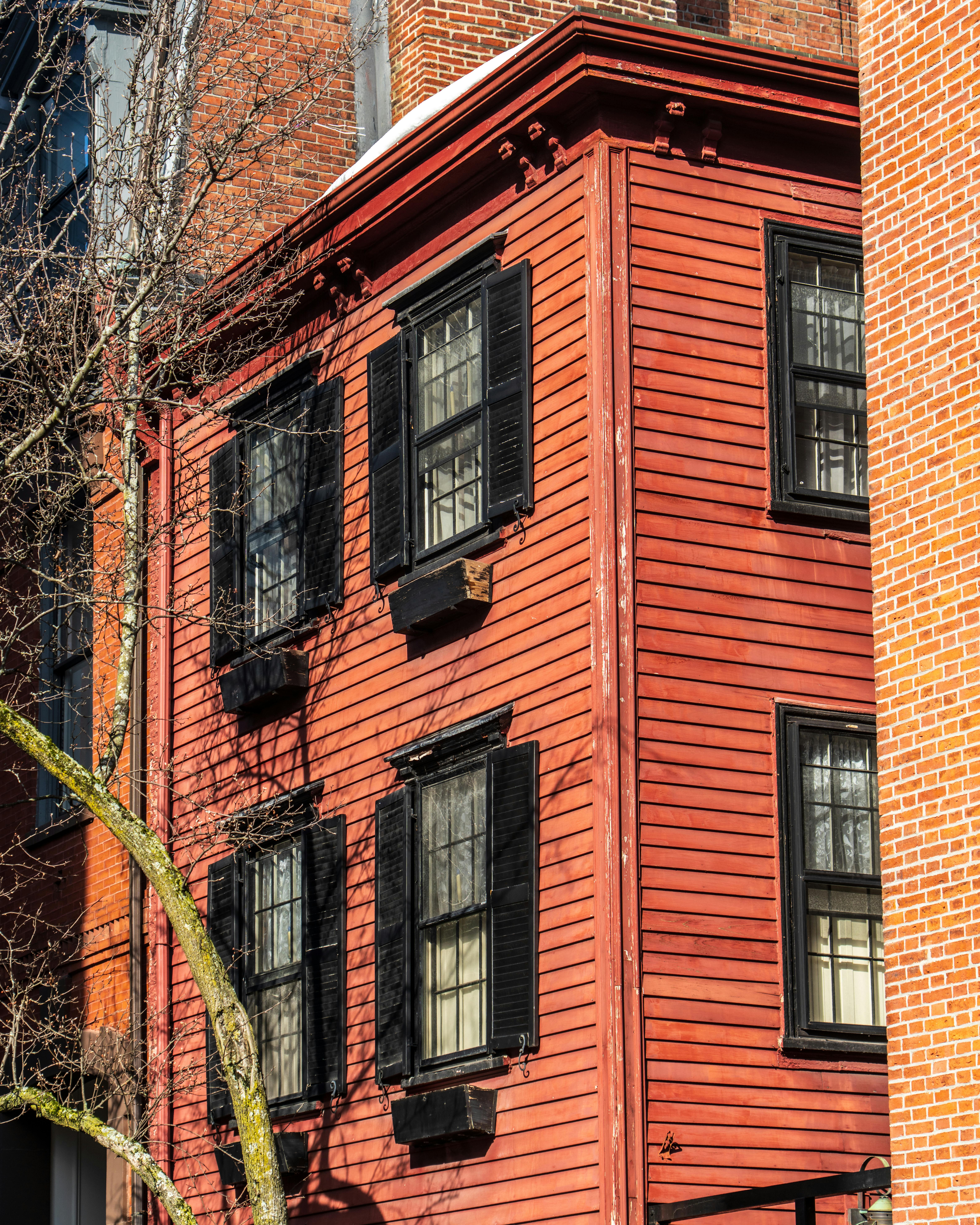 無料 ボストンにある、黒いシャッターが付いた魅力的な赤レンガの建物。クラシックな建築が際立っています。 写真素材