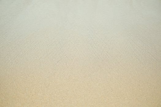 Minimalistic view of a sandy beach and calm sea, perfect for backgrounds and relaxation themes.