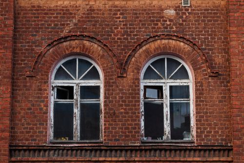 Free Detailed view of historic red brick building facade with arched windows in Pionersky, Russia. Stock Photo