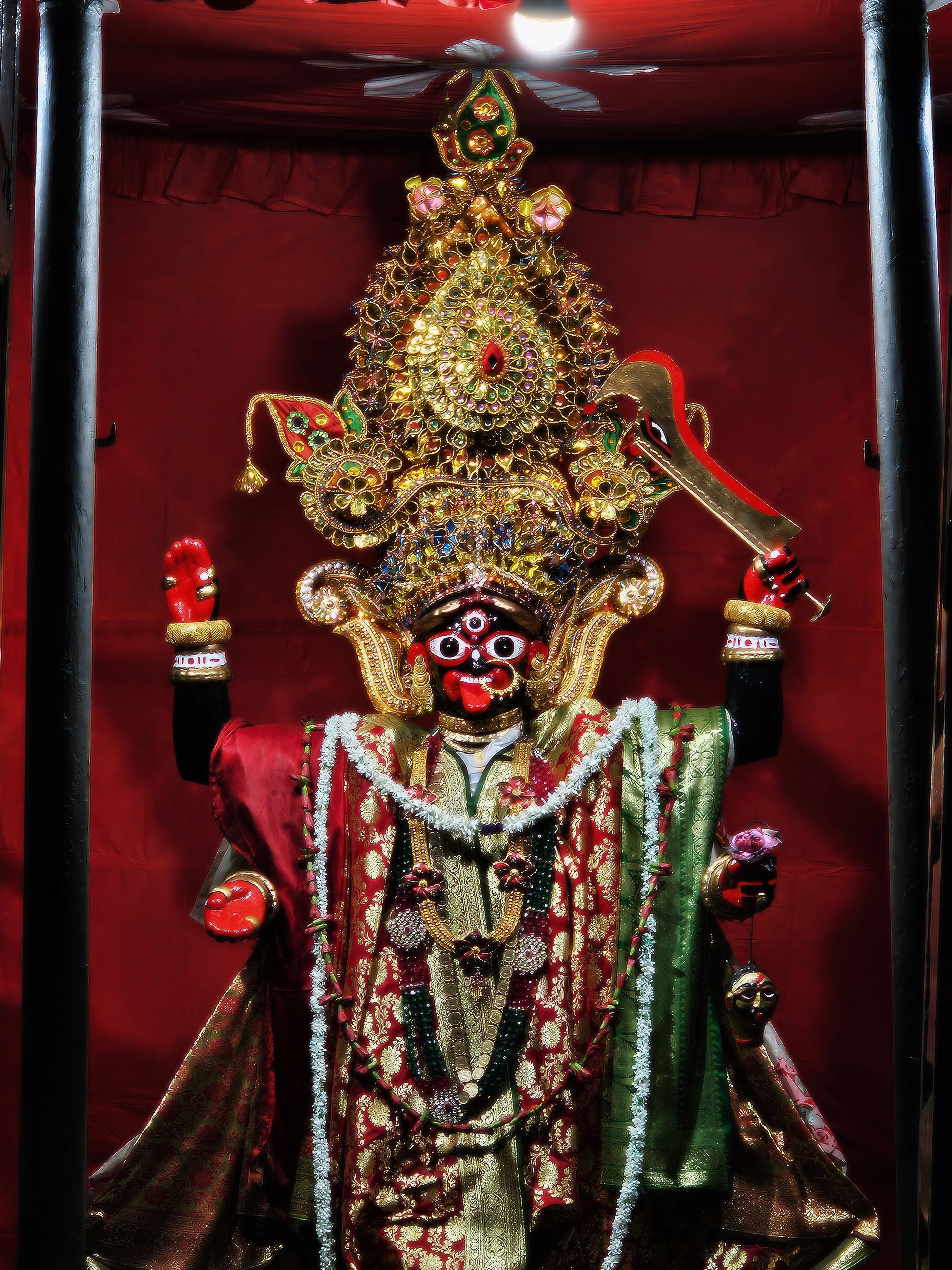 Colorful and ornate statue of Hindu Goddess Kali decorated with vibrant jewels and garments.
