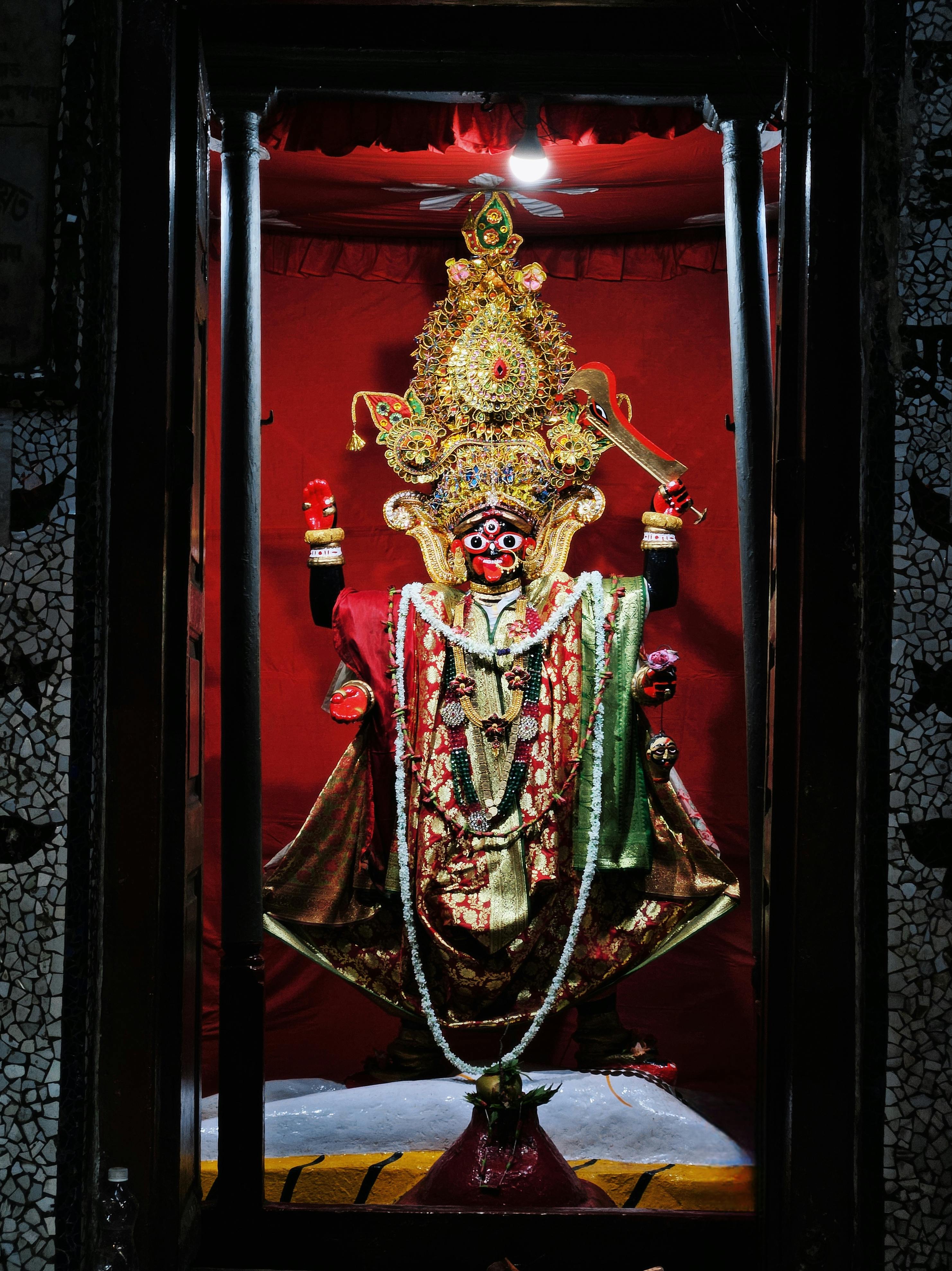 A beautifully decorated Hindu goddess idol inside a temple shrine, rich in cultural symbolism.