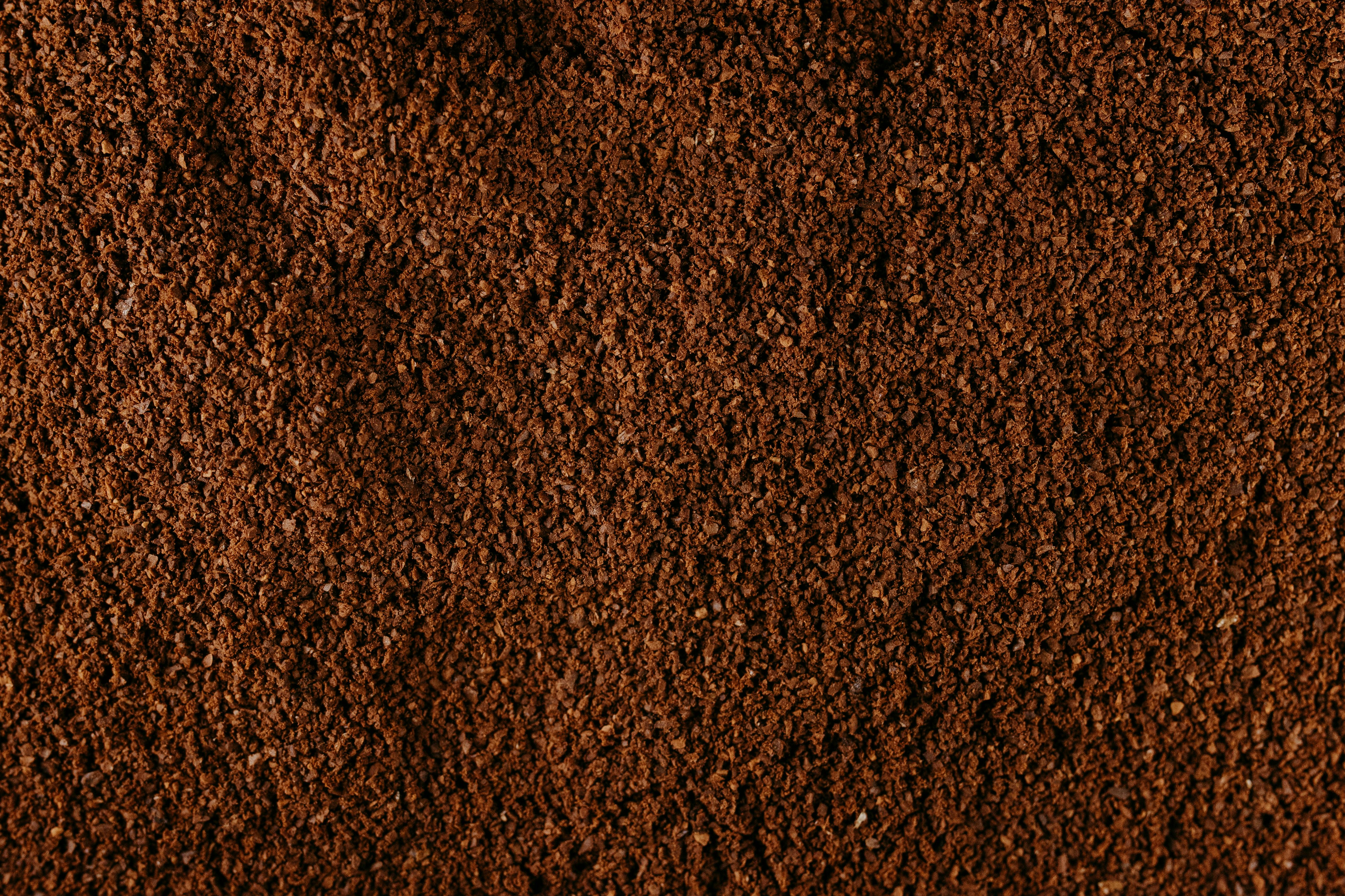 Free Detailed macro shot of ground coffee beans showing rich texture and color. Stock Photo