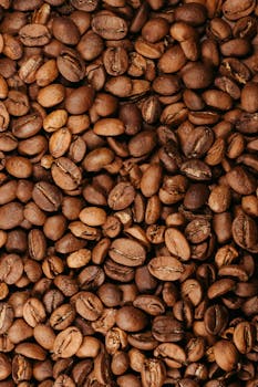 Detailed texture of brown roasted coffee beans, perfect for coffee-themed designs.