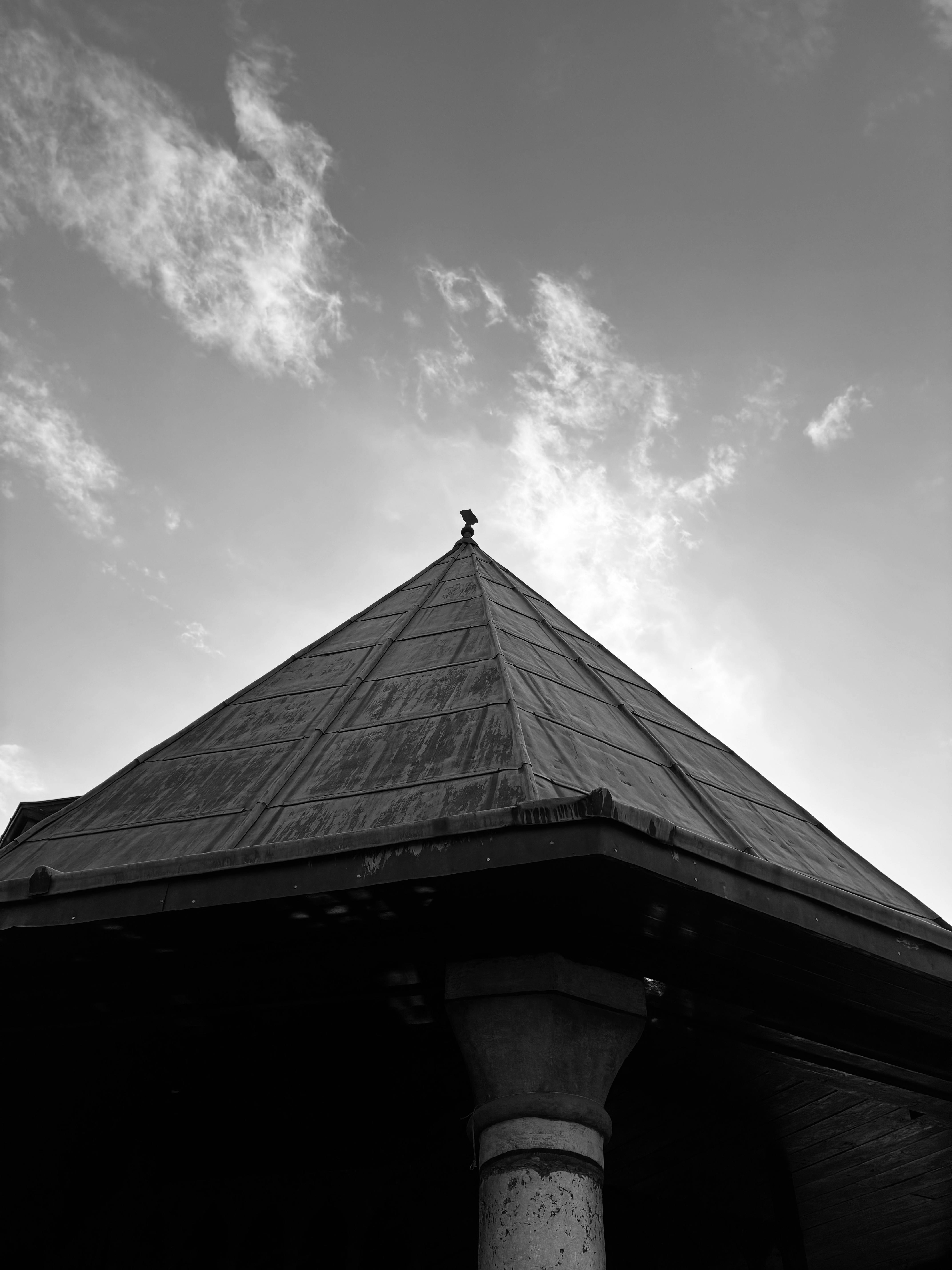 Free A black and white image of a triangular roof against a dramatic sky. Stock Photo
