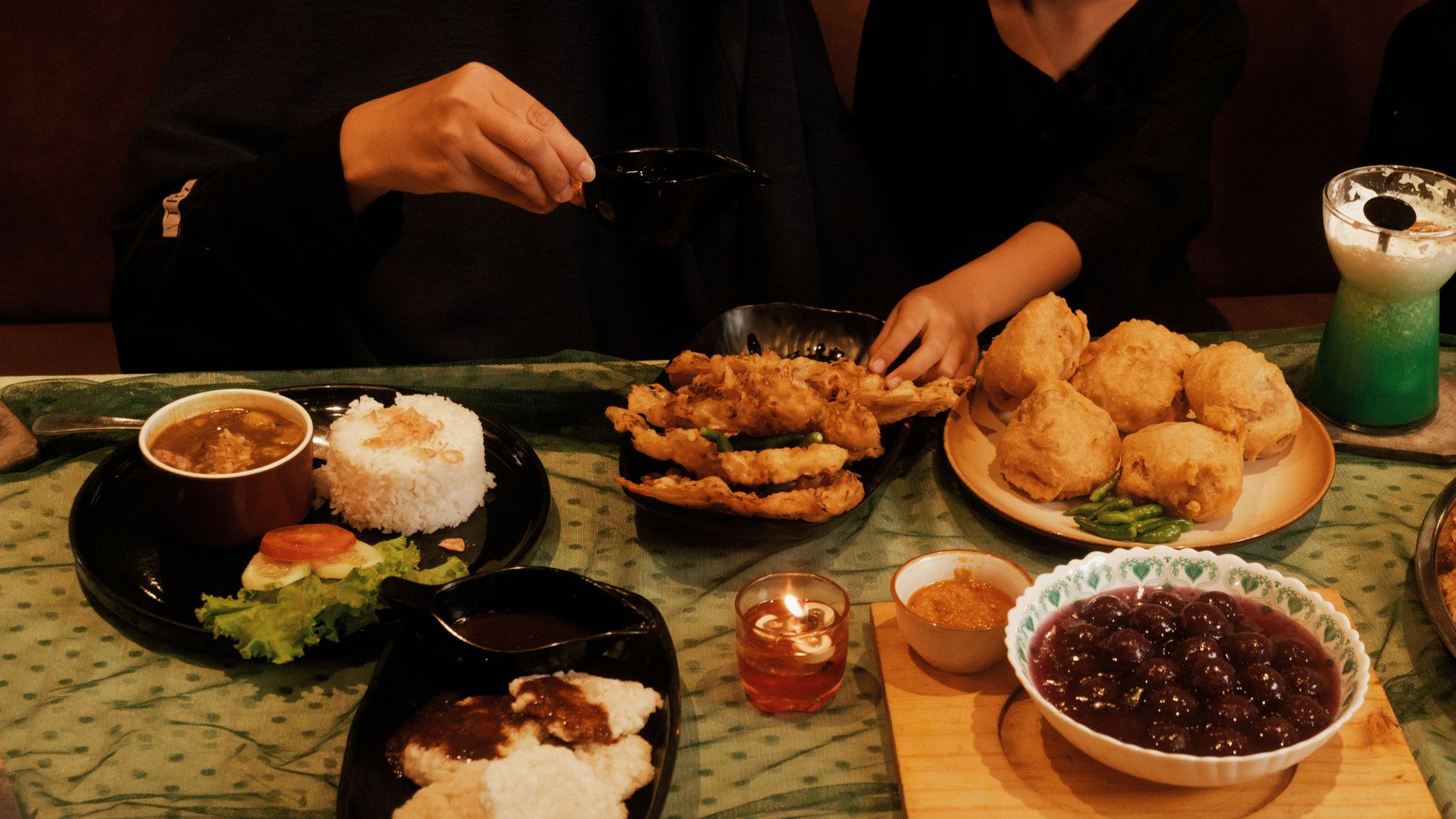 A warm setting with traditional Indonesian dishes enjoyed by a family during a cozy dinner.