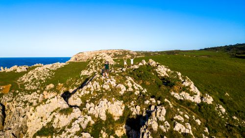 Free A stunning aerial view of the rocky cliffs and coastline in Asturias, Spain, with hikers enjoying the scenery. Stock Photo