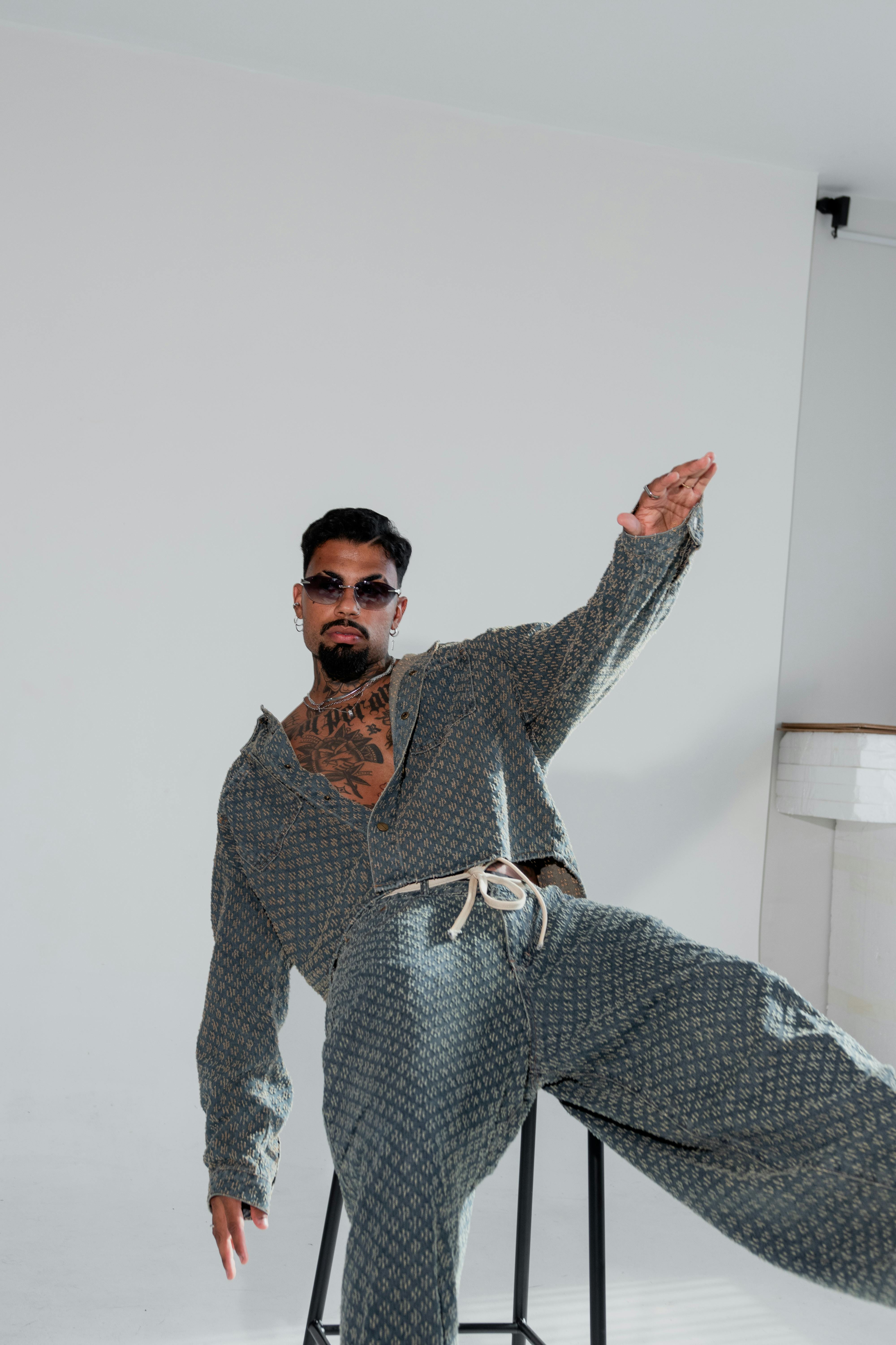 Ücretsiz Günlük kıyafetler giymiş, modaya uygun bir erkek model, minimalist bir arka plan önünde iç mekanda poz veriyor. Stok Fotoğraflar