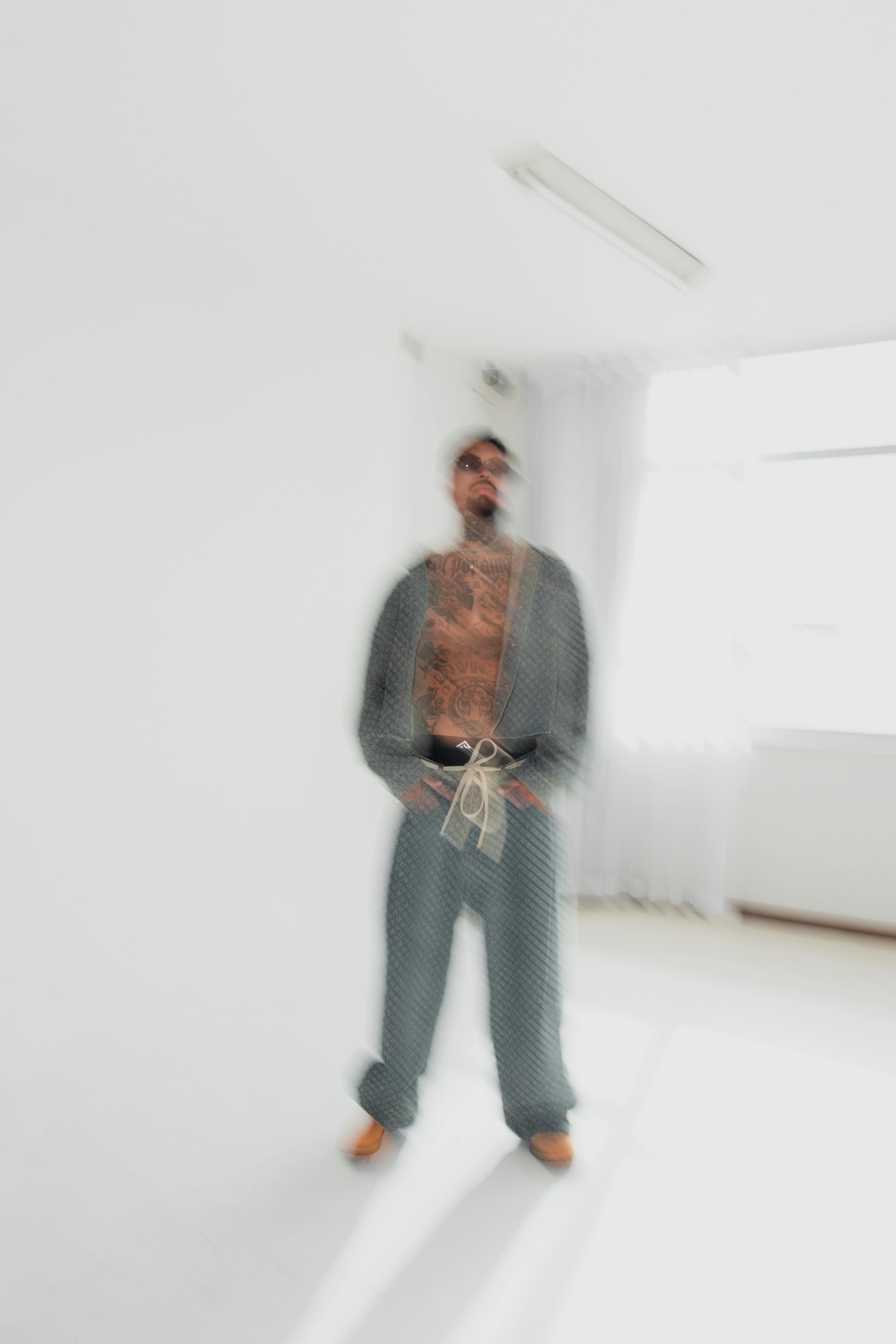 De franc Imatge artística borrosa d'un home tatuat amb vestimenta moderna, a l'interior. Foto d'estoc