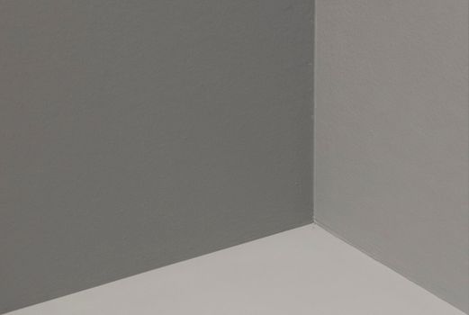 Abstract view of a minimalist corner with gray and white walls, showcasing simplicity and elegance.