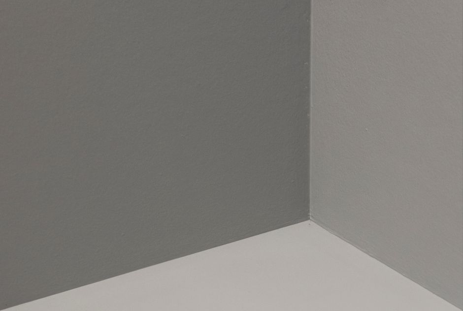 Abstract view of a minimalist corner with gray and white walls, showcasing simplicity and elegance.
