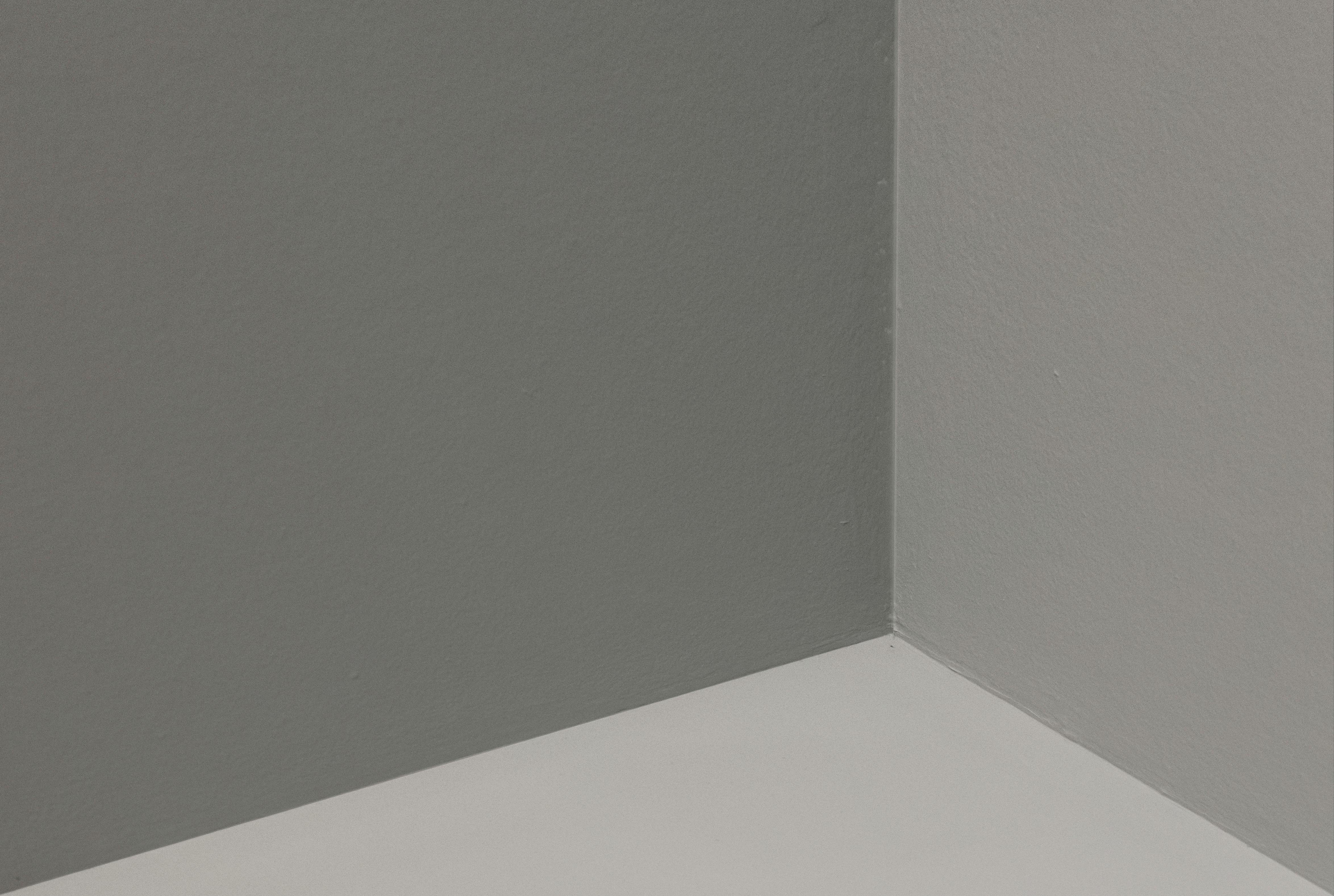 De franc Vista abstracta d'un racó minimalista amb parets grises i blanques, que mostra simplicitat i elegància. Foto d'estoc