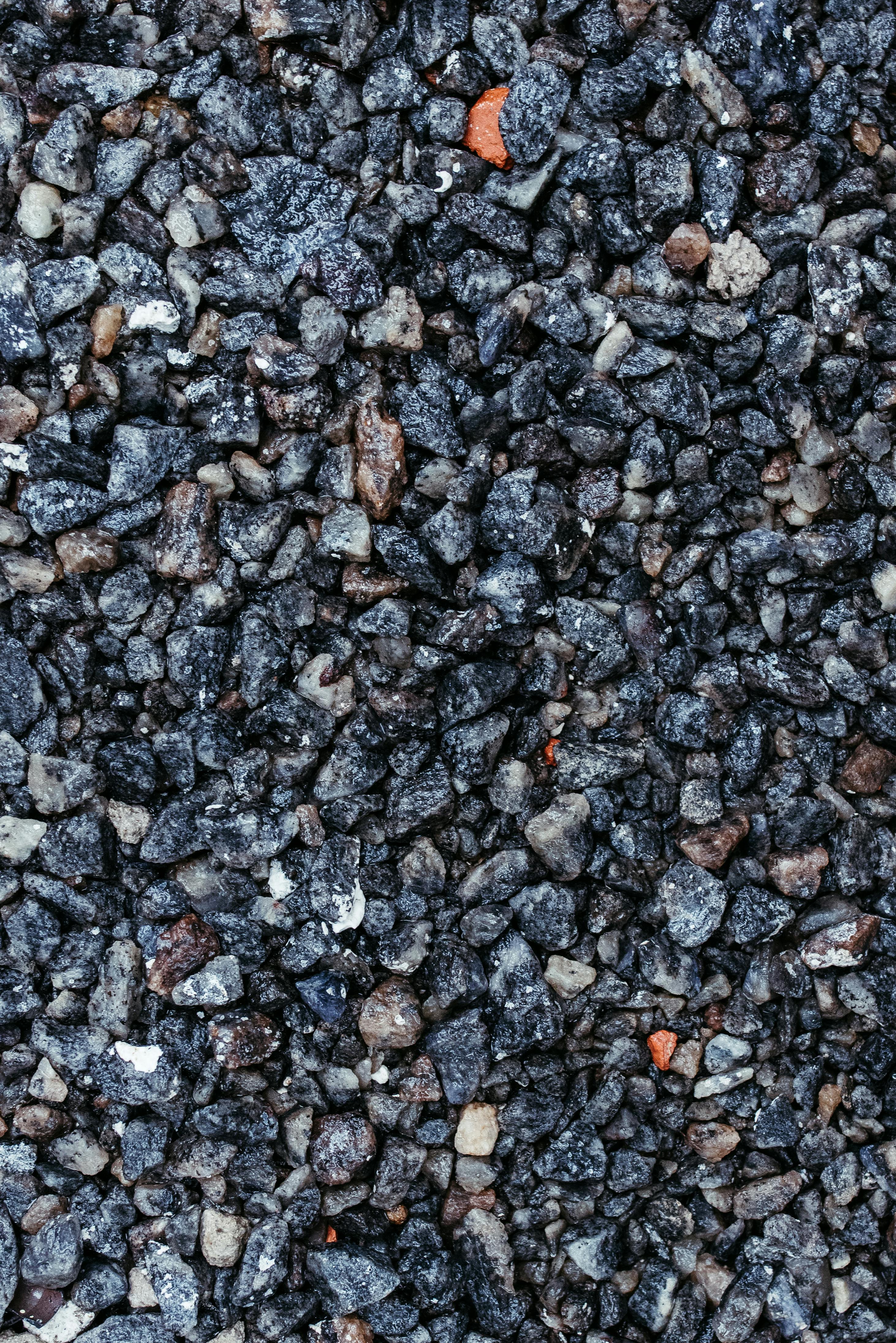 Free Detailed close-up of dark textured gravel, perfect for backgrounds or textures. Stock Photo
